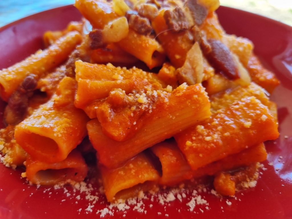 IMMAGINE DEL PIATTO DI PASTA ALL'AMATRICIANA FINITO CON LA SALSA DI POMODORO E GUANCIALE CON I RIGATONI
