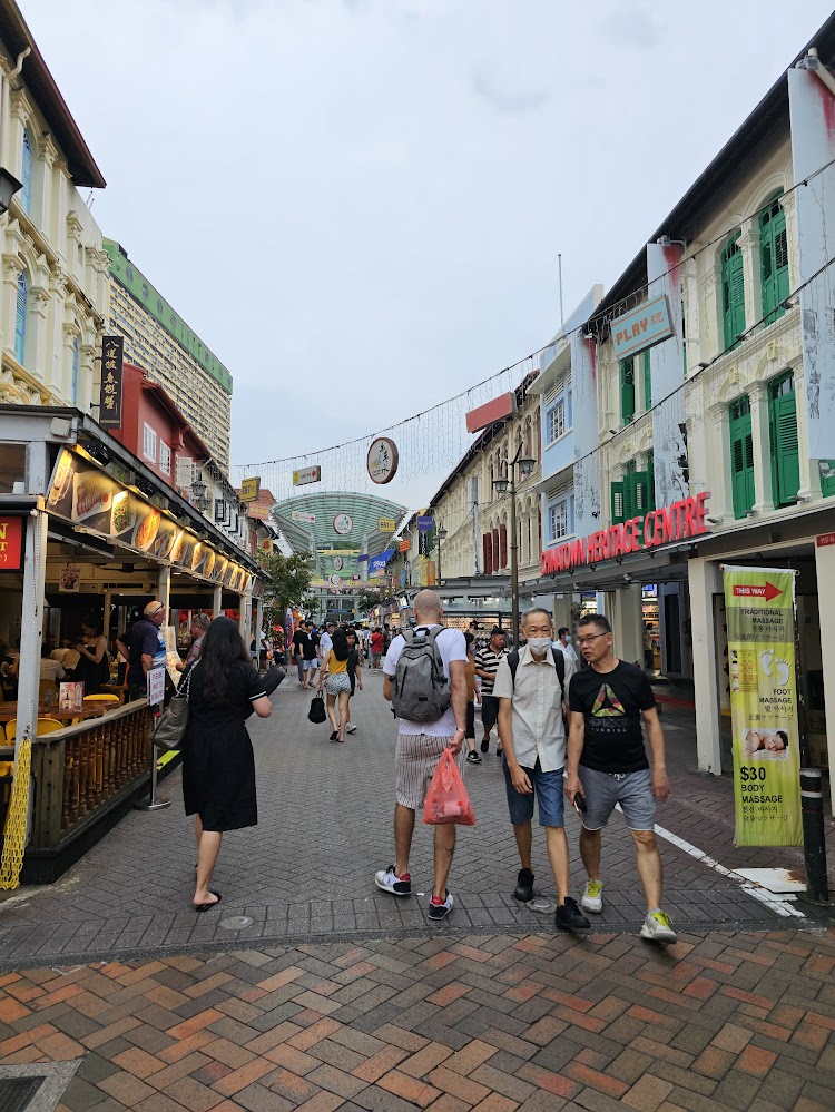 IMMAGINE DEL QUARTIERE DI CHINATOWN CON NEGOZI IN ENTRAMBI I LATI DELLA STRADA E PERSONE CHE CAMMINANO AL CENTRO