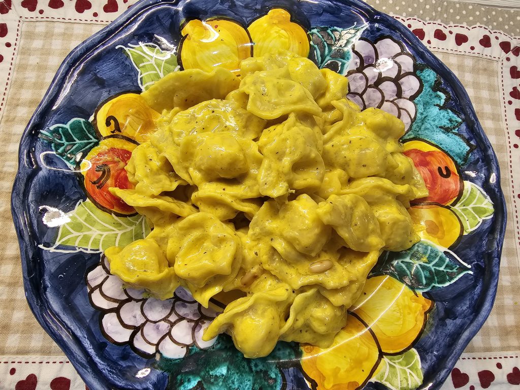 IMMAGINE DEL PIATTO CON I CAPPELLETTI EMILIANI CONDITI CON LA SALSA DI GORGONZOLA E MASCARPONE CON ZAFFERANO E PINOLI