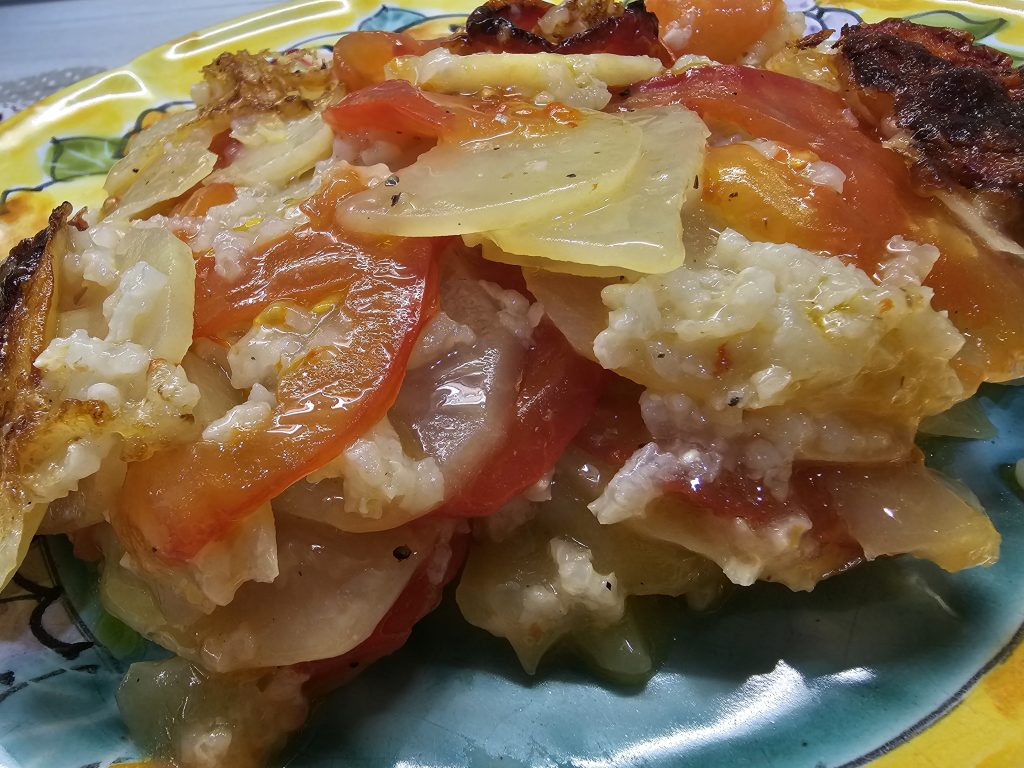 IMMAGINE DEL PIATTO SERVITO CHE RAFFIGURA GLI STRATI COTTI DEI POMODORI CON IL RISO E LE PATATE