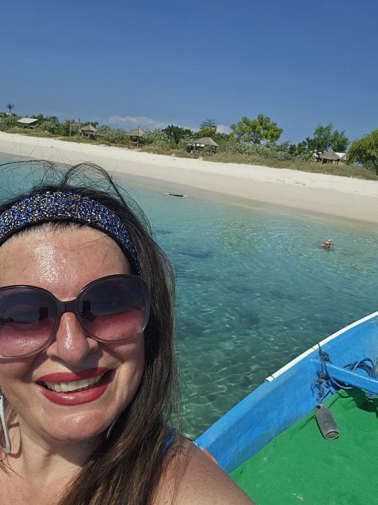 IMMAGINE DELL'AUTRICE IN BARCA CON LO SFONDO DELL'ACQUA VERDE